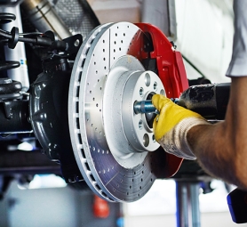 Car mechanic in a garage repairs a bracke